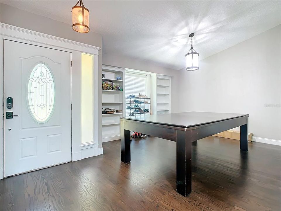 Foyer and front formal dining room with built in bookshelves