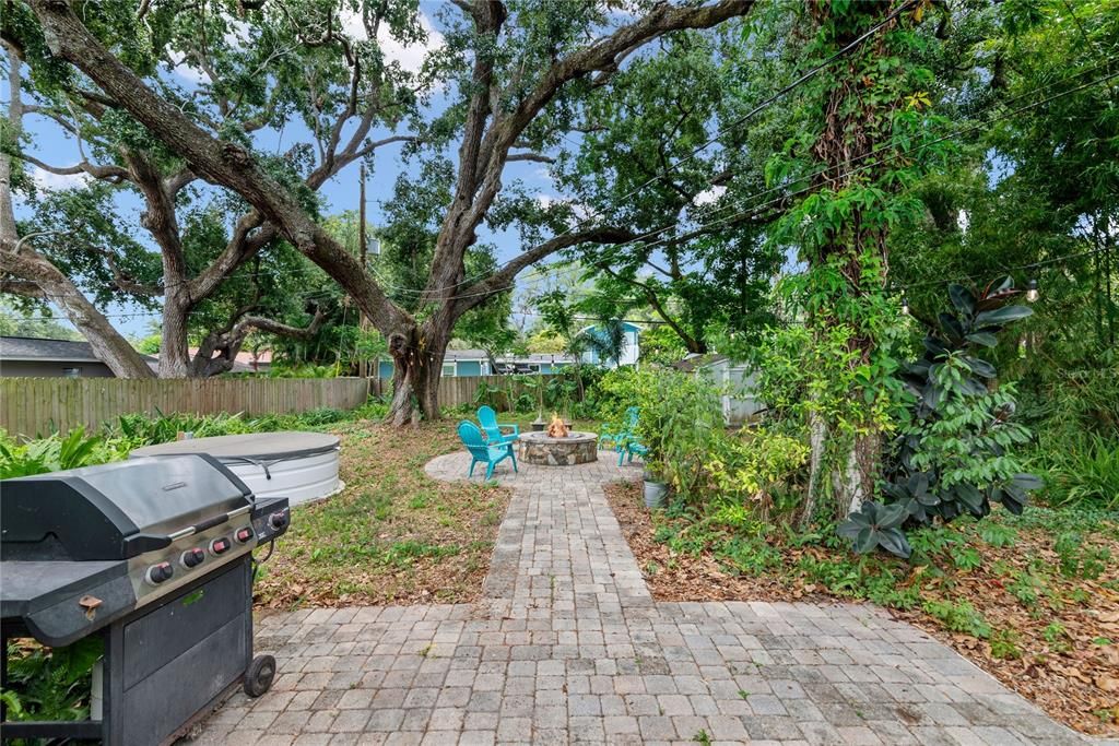 Backyard features a wood deck leading to a paved patio, great for grilling, sun chaise chairs or a additional seating. Leads to fire pit.