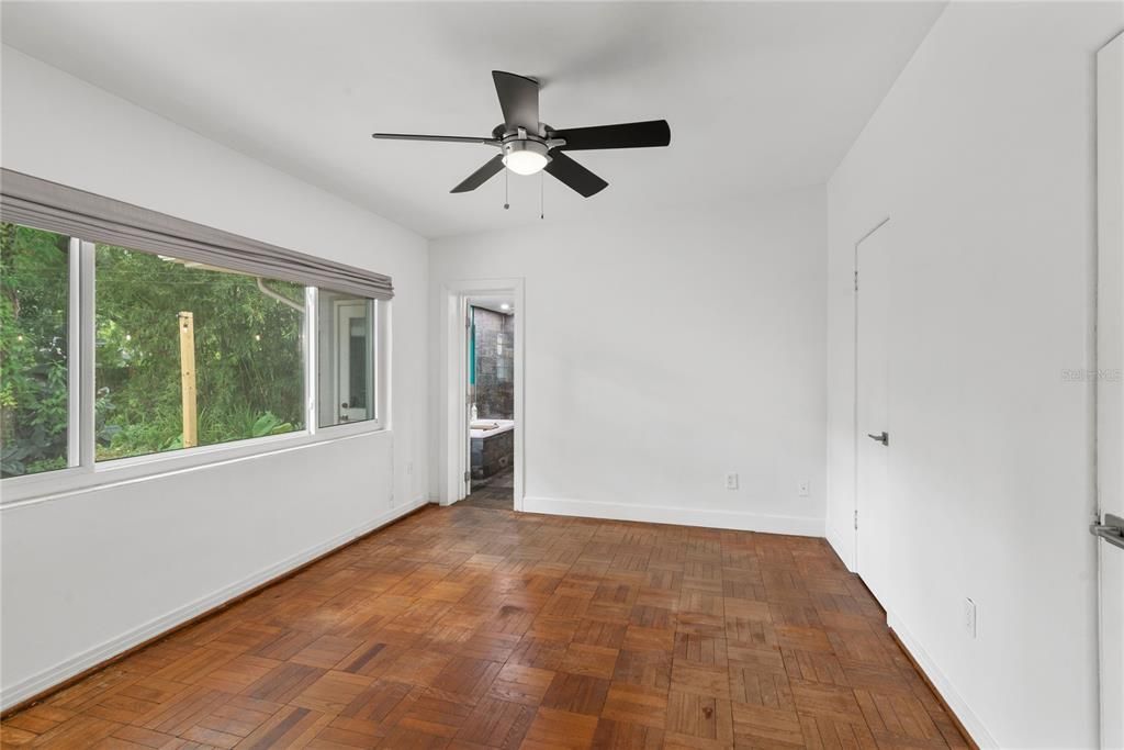 Primary bedroom has large window overlooking backyard.