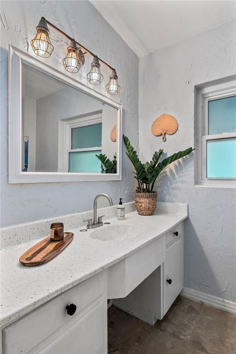 This second bathroom is located in the hallway just off the living room, between the two bedrooms.