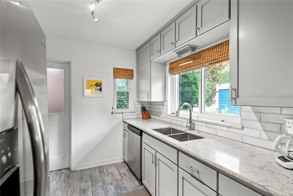 Remodeled kitchen features solid wood cabinets, quartz countertops, stainless steel fridge, dishwasher and oven.