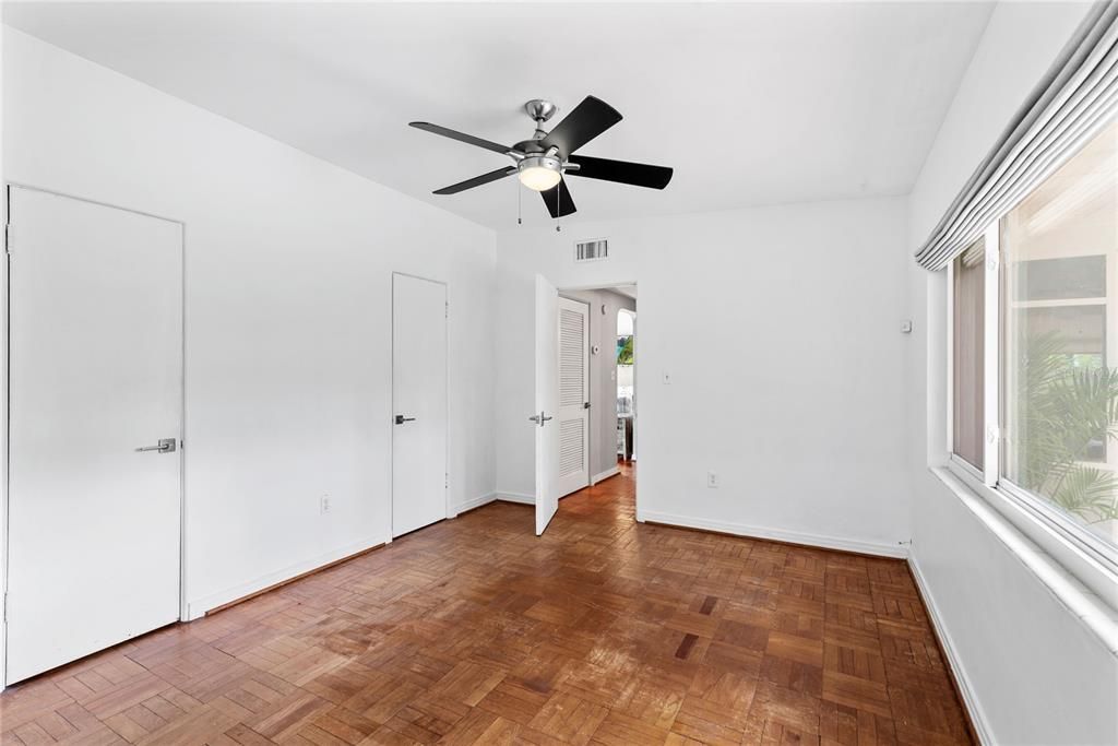 Primary bedroom includes two closets; one with built-in shelves in addition to main closet rod.