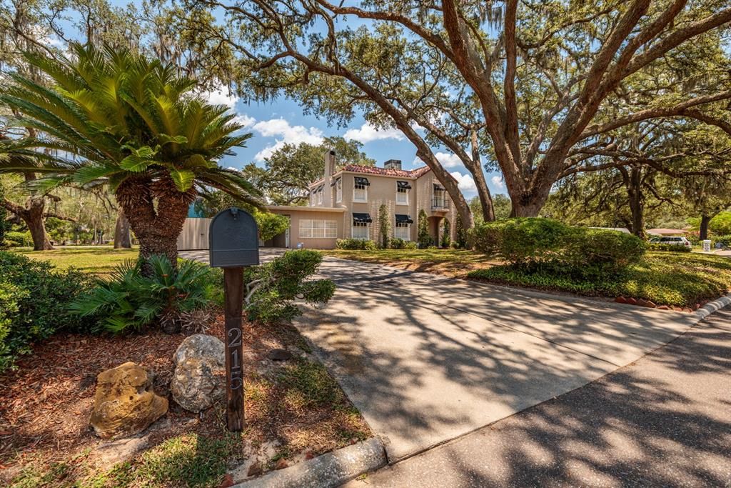 The John Perry House is nestled under a well maintained canopy of oaks