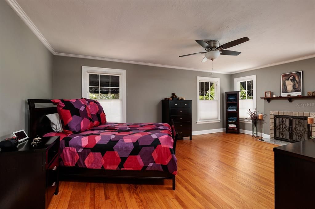 Wooden floors and large windows in the primary bedroom