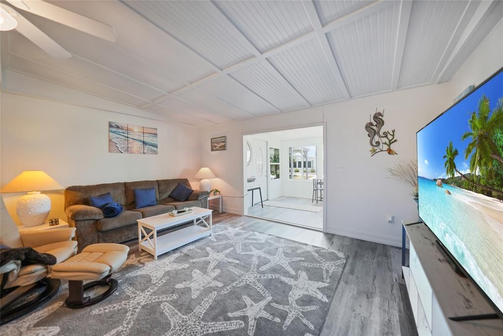 Living room with high ceilings looking bac to lanai and front door