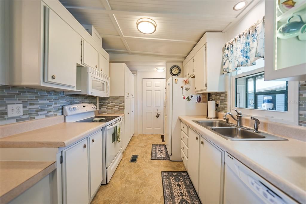 Kitchen view with beautiful backsplash, same ceiling throughout and great views at the sink area