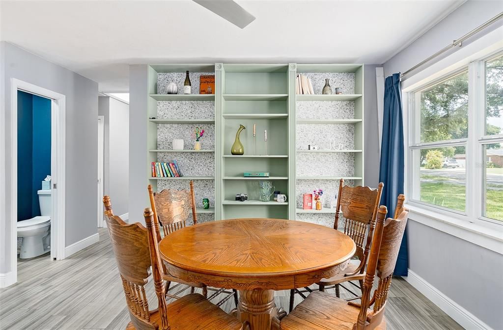 Dining Room with built in shelving. Adjacent to the kitchen. Updated lighting. Luxury vinyl plank flooring throughout.