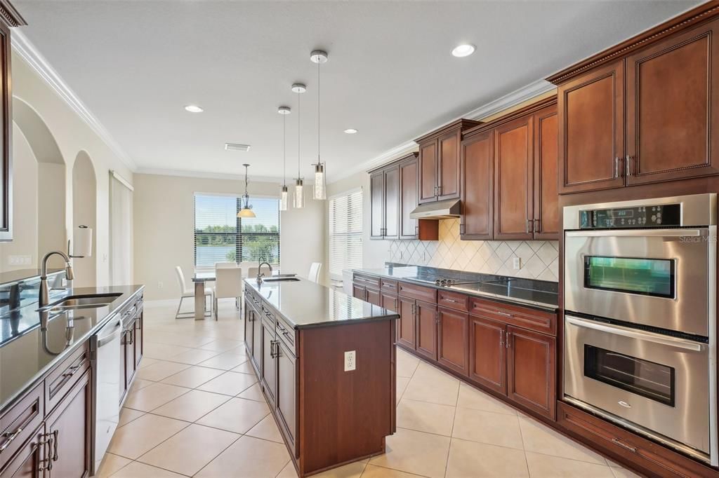 Gourmet kitchen with double wall ovens, stainless steel appliances, extra counter space, and plenty of storage space