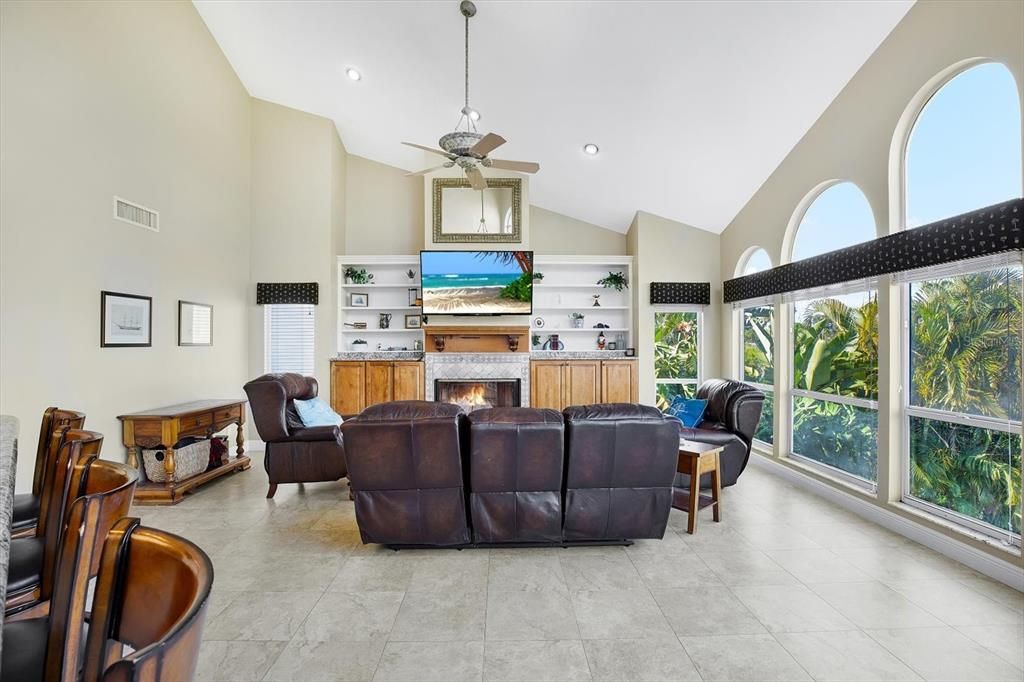 Another wood burning fireplace flanked by built-ins and those gorgeous arched windows round out the family room