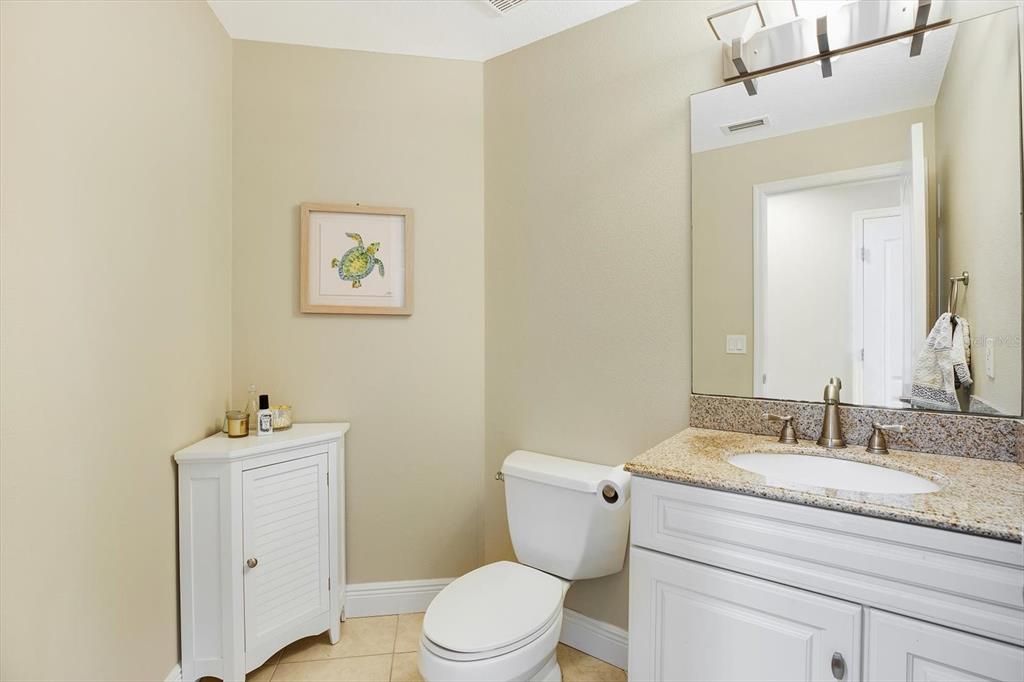 The updated guest half bath is situated in the hall off the living and dinig space