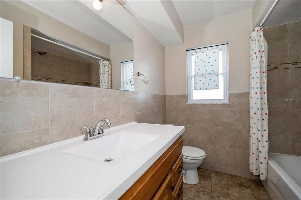 Bath has tub/shower combo with large vanity