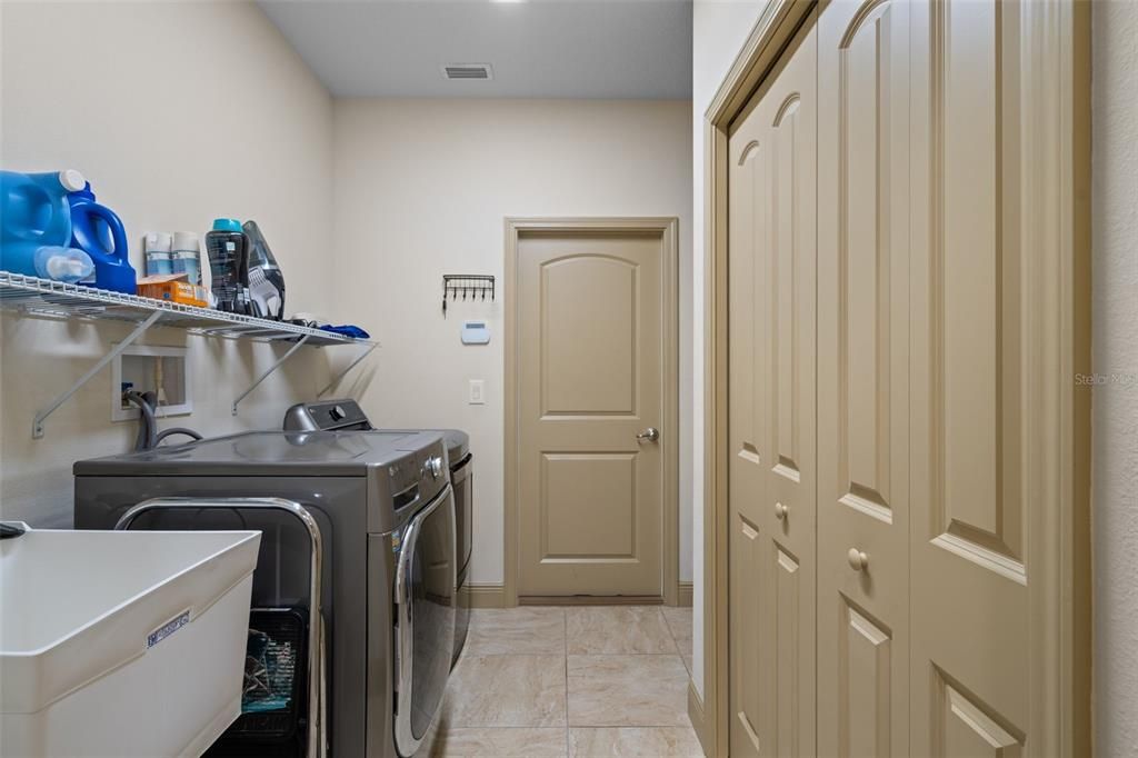 Inside laundry room with a sink and additional storage closet.