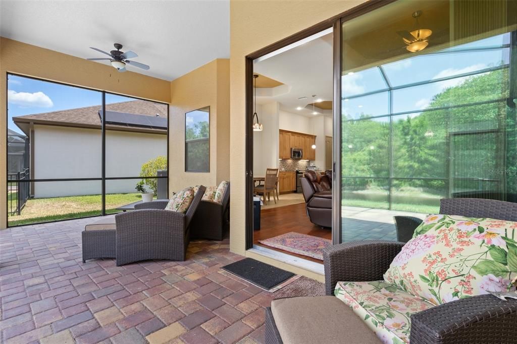 Sliding glass doors from living room lead out to the screened in patio