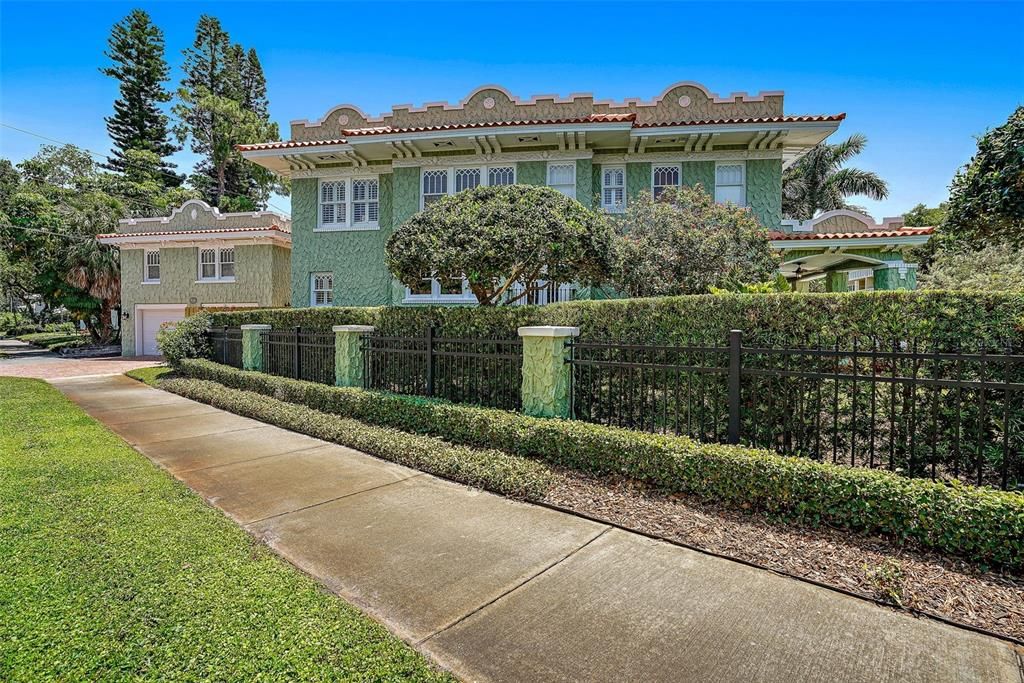 Side view of this spacious front yard - surrounded by new columned & custom iron fencing with new wood fence on alternate side