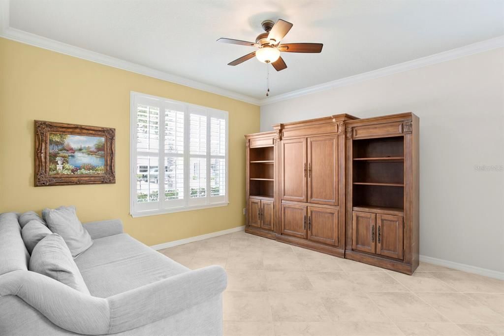 Just off the foyer is the formal living room with crown molding and a ceiling fan