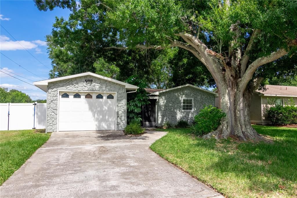 Stone facade with long driveway.