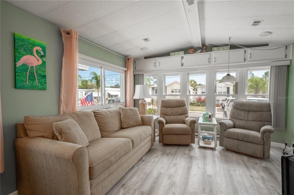 The living room is filled with natural light. A vaulted ceiling creates an airy feel.