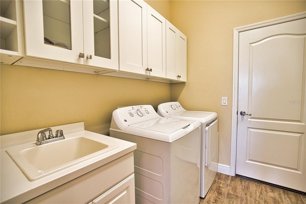 Laundry room with full upper cabinets and laundry sink