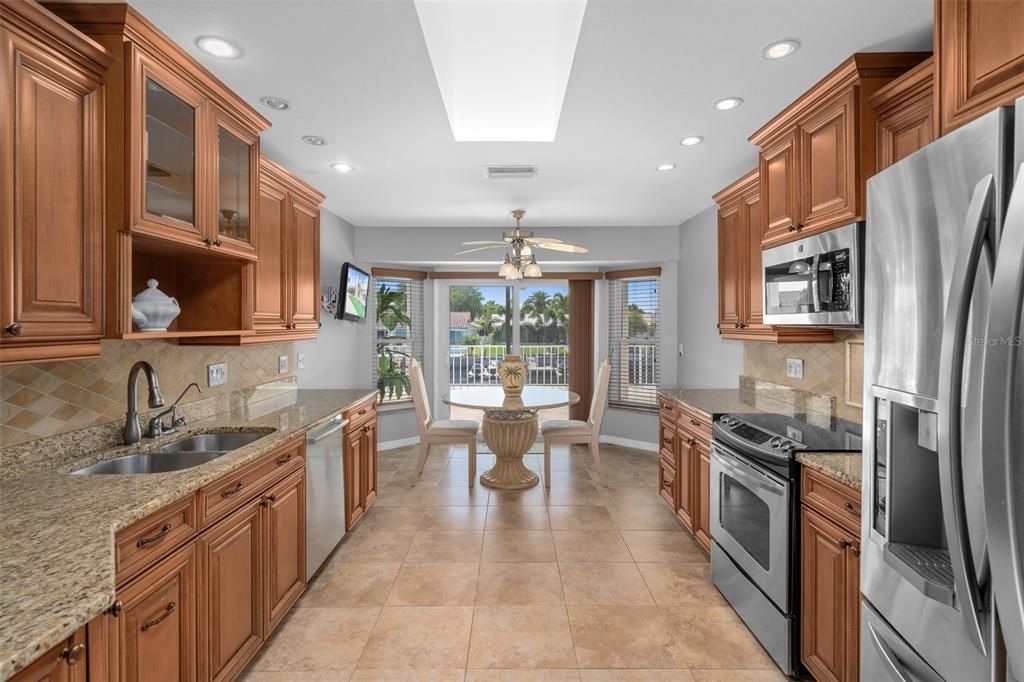 Sliding doors out to the patio and water view.  Beautiful kitchen - you don't like wood cabinets you can always paint them white.  Solid wood.   Great Breakfast area. Skylight