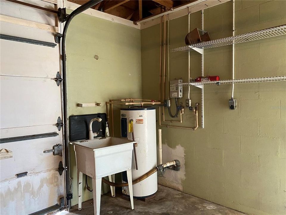 Laundry in garage including sink