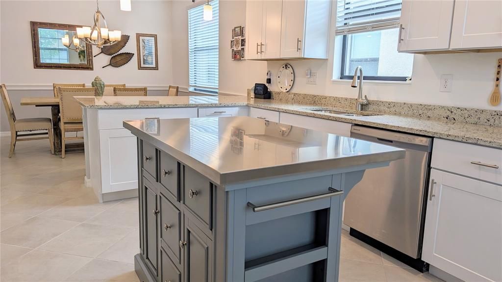 Custom kitchen island with stainless top provides extra storage and workspace