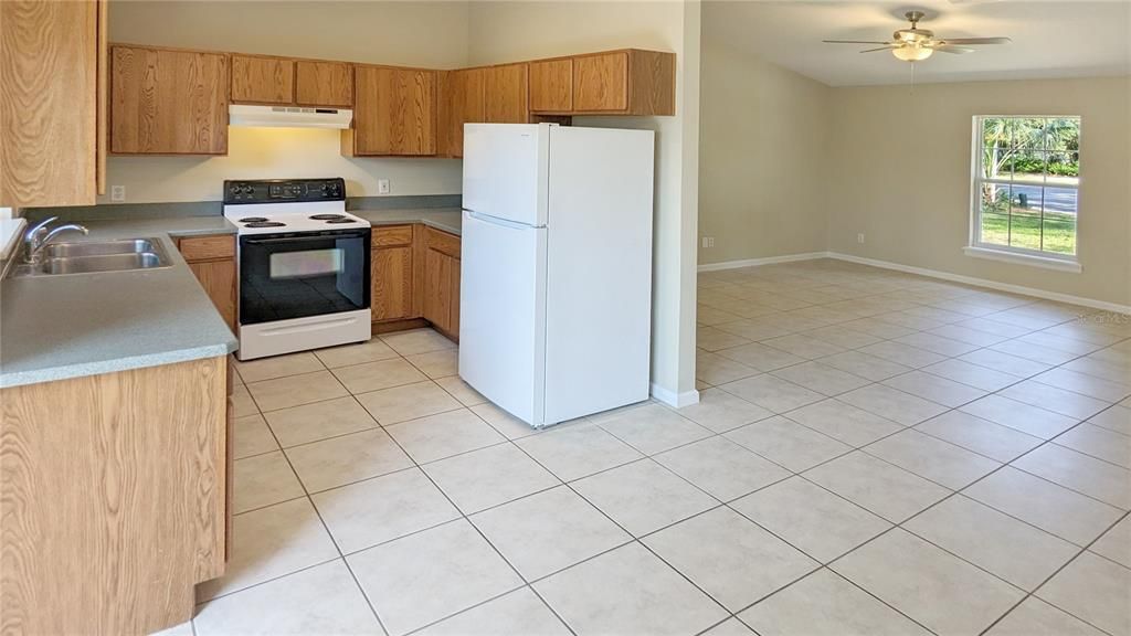 View of Kitchen, Dining Room and Living Room as seen from Slider Doors to Tree-Shaded large Backyard!