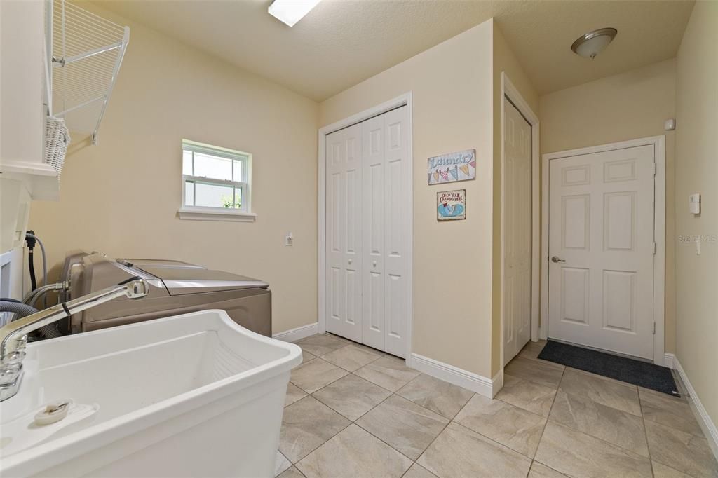 Laundry room has double closets, built-in shelving and a utility sink!