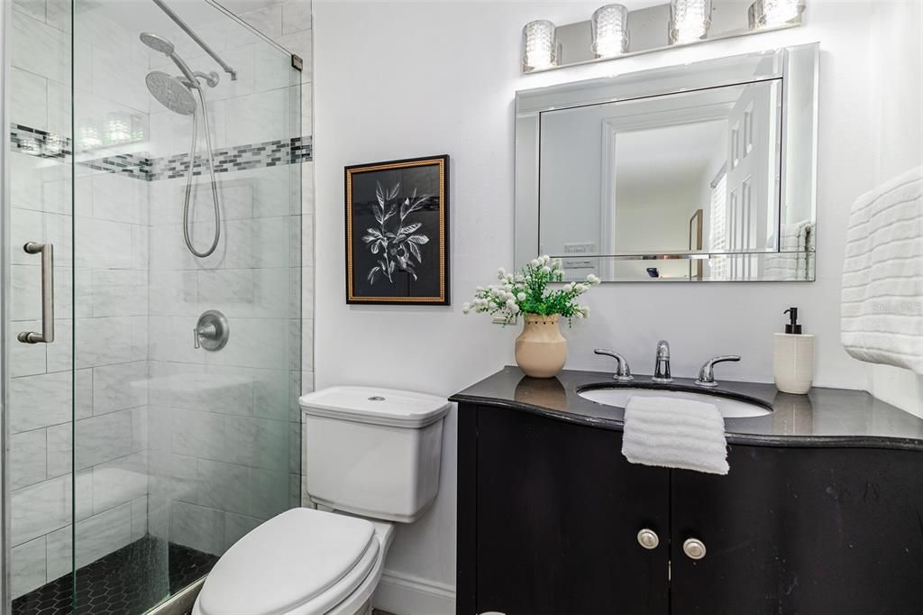 Primary ensuite bathroom with granite vanity and walk-in shower
