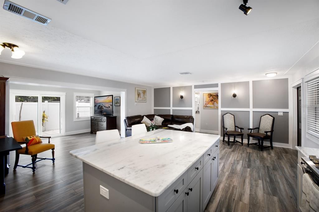 Large Kitchen island with stone counter is a perfect place to sit with a cup of coffee while you plan your day.