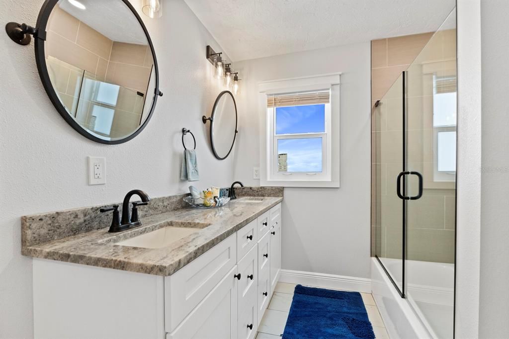 The second bathroom has a tub with a shower, stone counters and tons of storage, the windows let in as much natural light as you'd like.