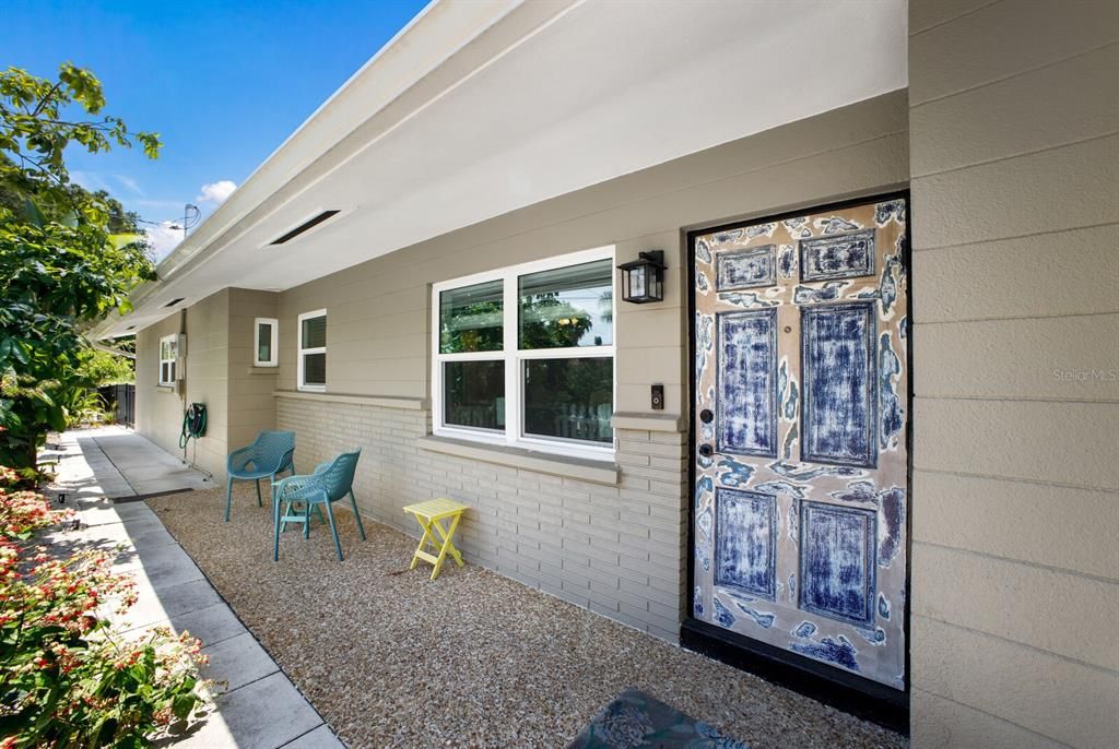 The front of the home has a patio shaded by the eves that looks out over the garden.