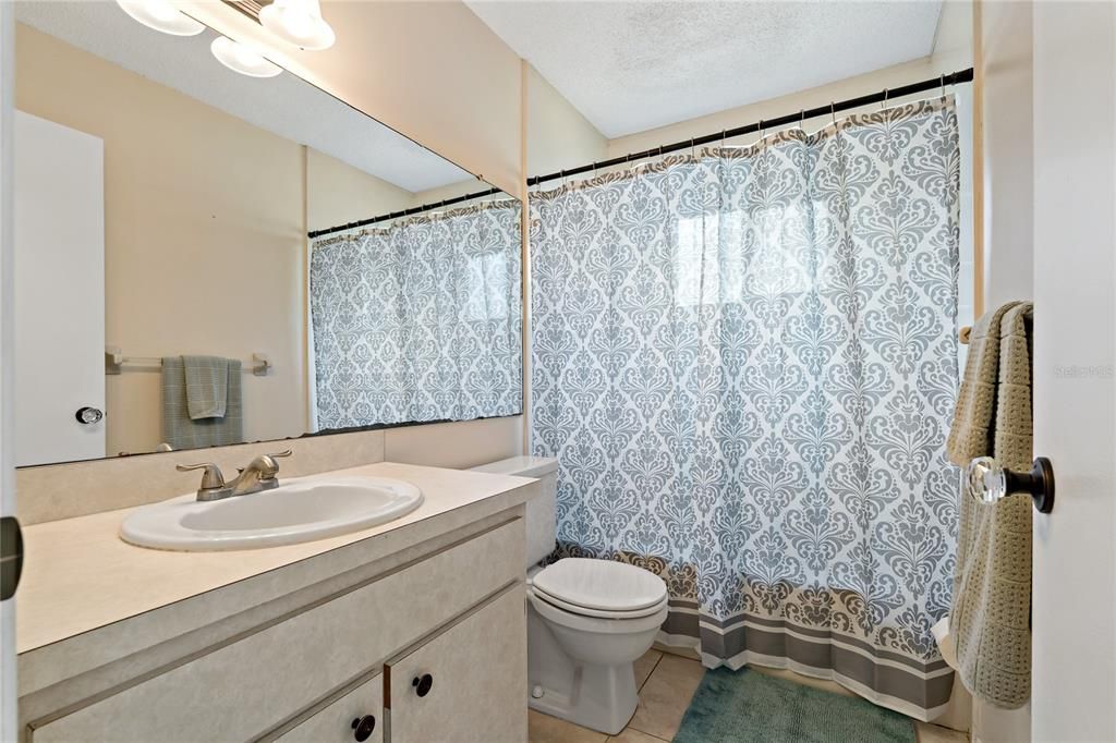 GUEST BATHROOM WITH SOAKING TUB/SHOWER COMBO! NOTICE THE COOL GLASS DOOR KNOBS ON ALL DOORS, NO FINE DETAIL UNTOUCHED HERE!