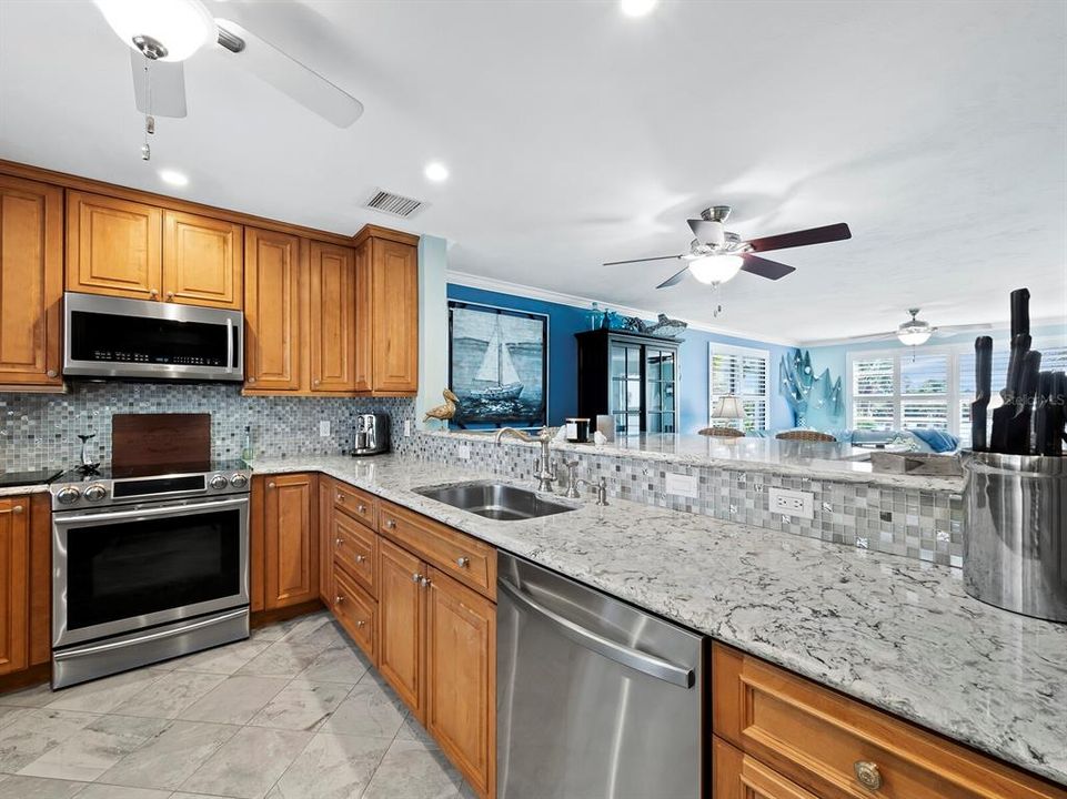 Stainless steel appliances, a gorgeous backsplash and an expanse of beautiful Cambria Quartz countertops that open to the light filled living and dining room, all the while looking at the spectacular view