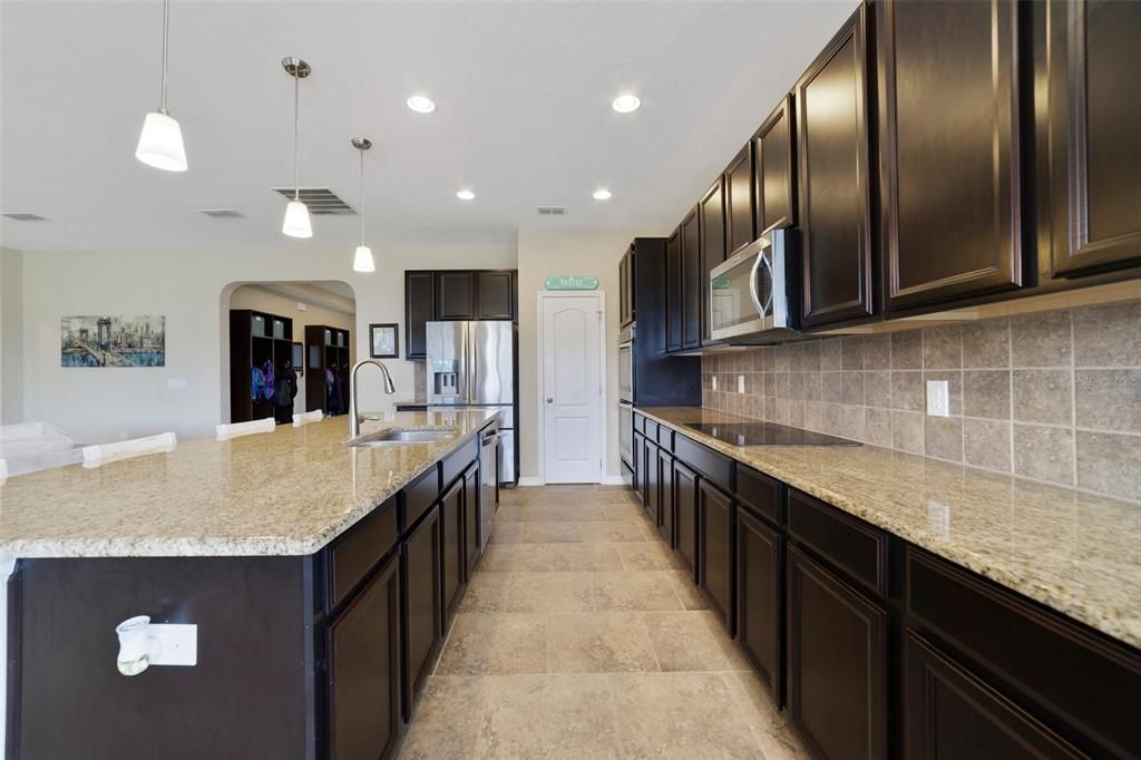 The family chef will delight in the gourmet kitchen featuring BUILT-IN DOUBLE OVENS, tiled backsplash, stone counters, STAINLESS STEEL APPLIANCES, walk-in pantry and the breakfast bar on the oversized ISLAND provides additional casual dining perfect for entertaining!