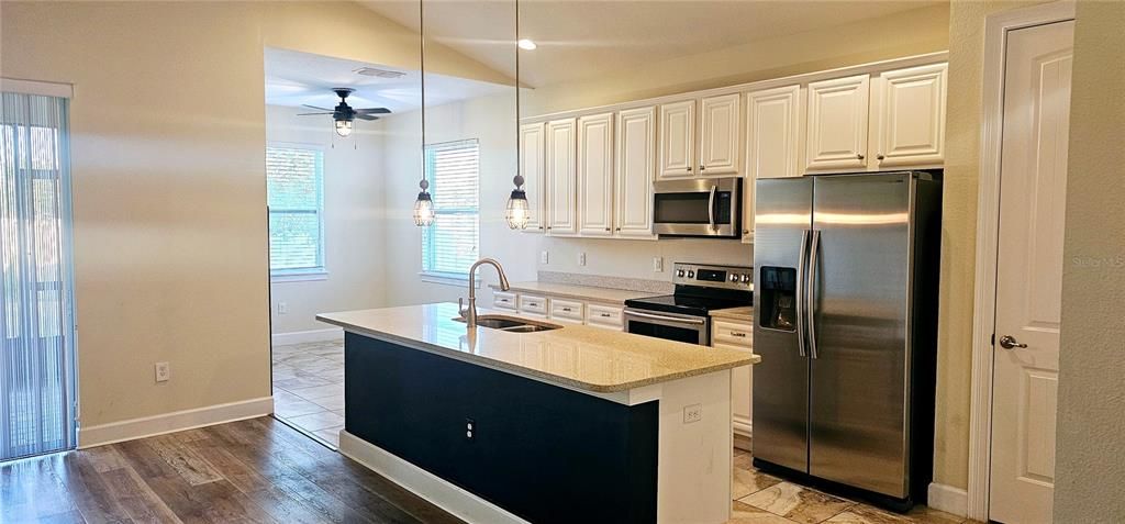 Beautiful open concept Kitchen with huge Quartz breakfast bar, Pendent and recessed lighting, 42" cabinets, SS appliances and separate Breakfast Nook.