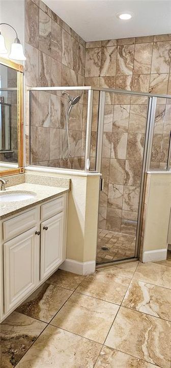 Primary En Suite Bathroom with two vanities with Quartz counters and bench space.