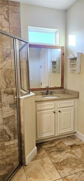 Primary En Suite Bathroom with two vanities with Quartz counters and bench space.