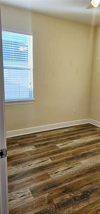 Guest Bedroom 2 with easy-to-clean laminate flooring, and ceiling fan.