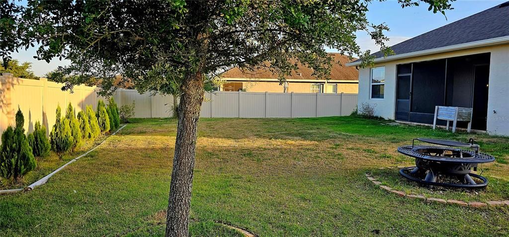 Fenced backyard view of Exterior and of screened Lanai.