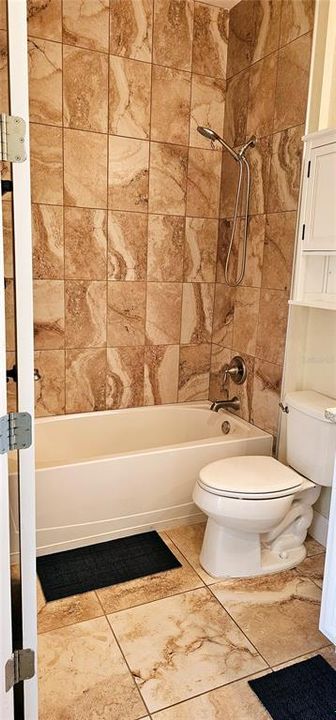 Guest Bathroom with porcelain tiles and tiled shower/tub combo, and vanity with Quartz counters.