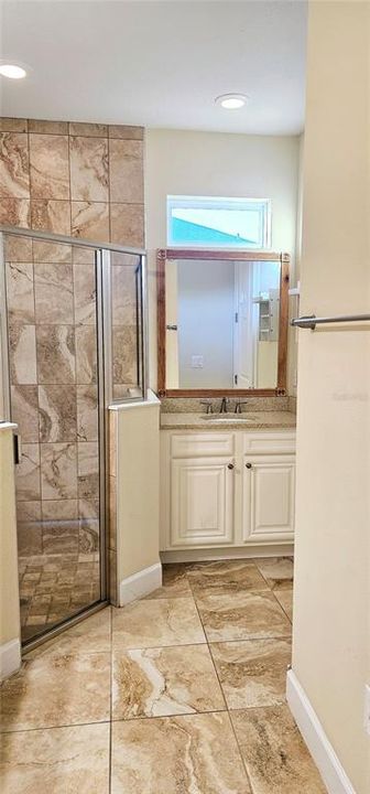 Primary En Suite Bathroom with two vanities with Quartz counters and bench space.