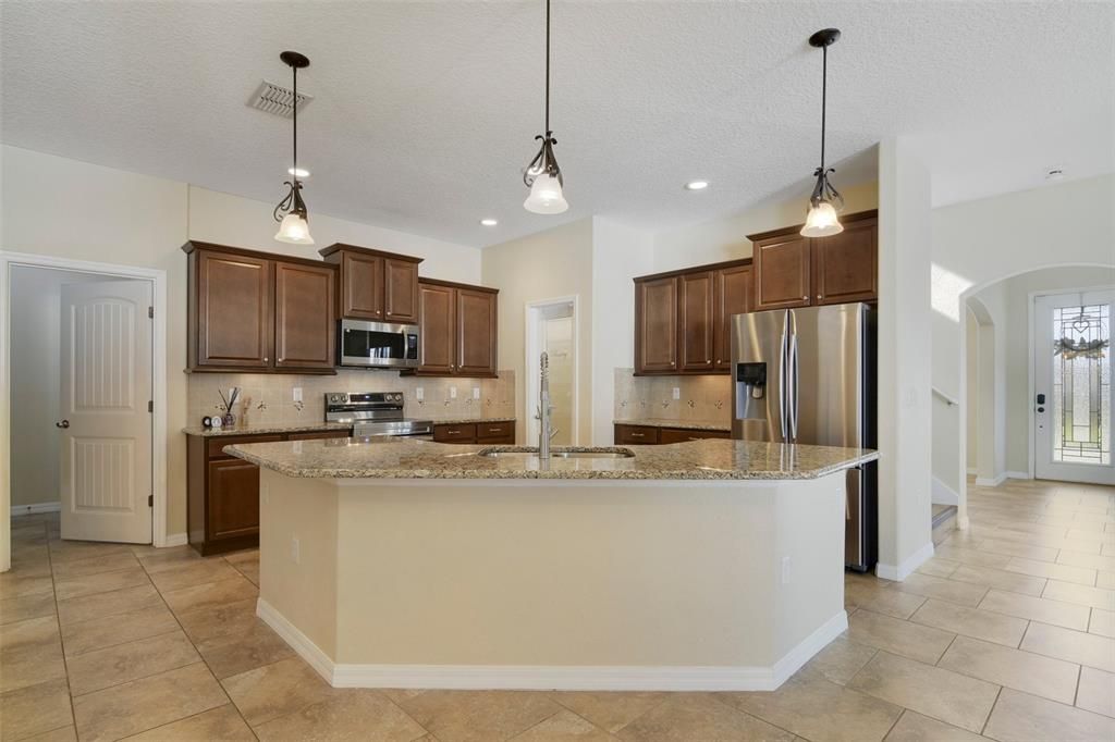 The home chef will appreciate the thoughtful design of the modern kitchen offering rich solid wood cabinetry, GRANITE COUNTERS, decorative backsplash, STAINLESS STEEL APPLIANCES, pendant lighting over the breakfast bar and the WALK-IN PANTRY gives you ample storage.