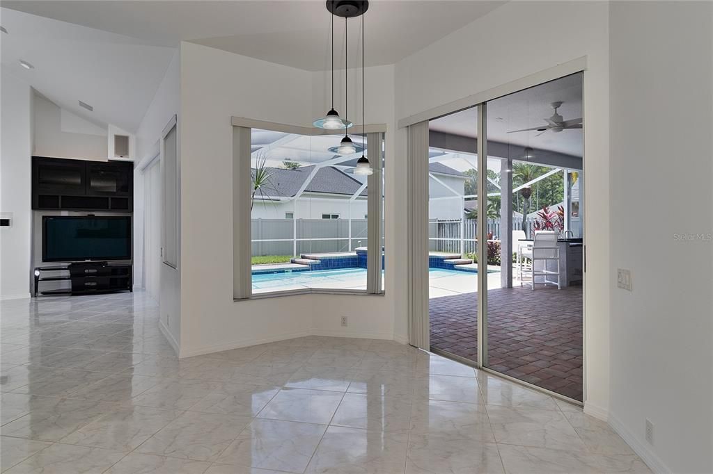 INFORMAL DINING AREA OVERLOOKING THE POOL/OUTDOOR PATIO AND OUTDOOR KITCHEN