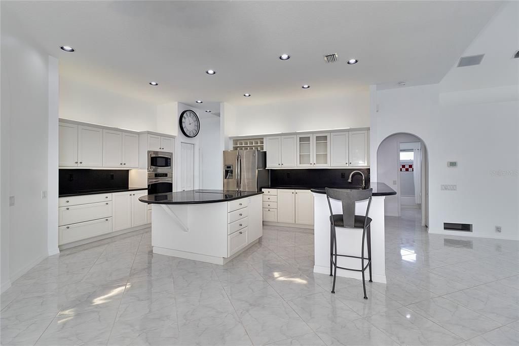 KITCHEN FROM CASUAL DINING AREA OPENING TO POOL