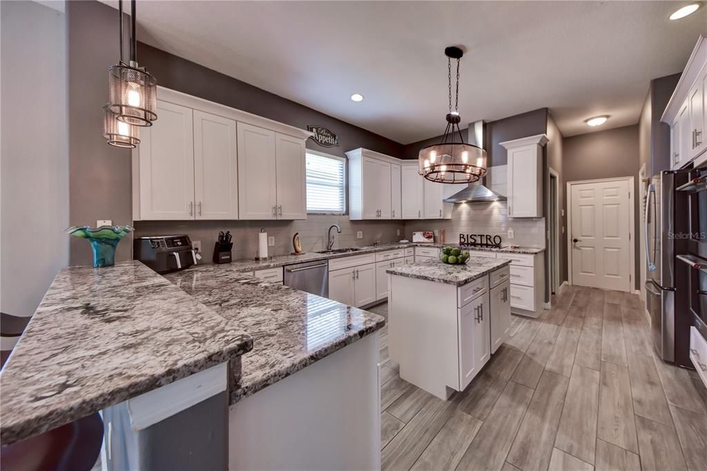 Completely Remodeled Kitchen Boasting Double Oven, Gourmet Induction Oven W/ Range Hood, Granite, Soft Close Drawers and Cabinets, Kitchen Island w/ Ample Storage, Updated Lighting Fixtures and Walk In pantry,