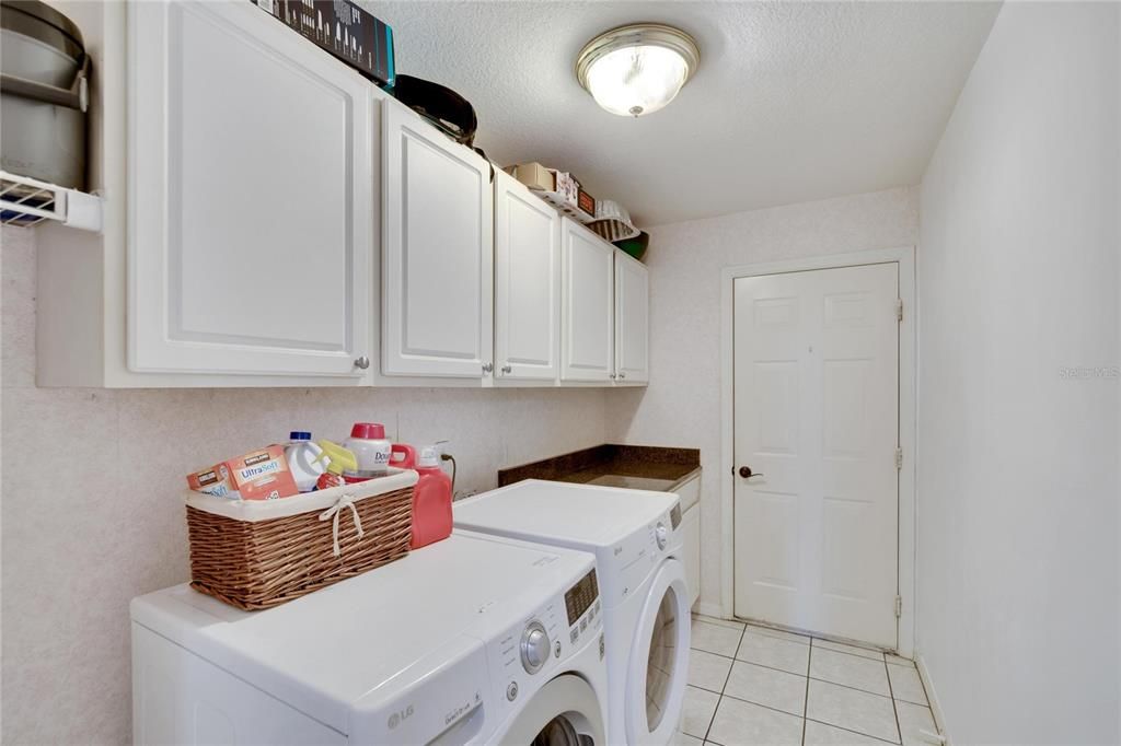 Laundry room with upper and lower cabinets