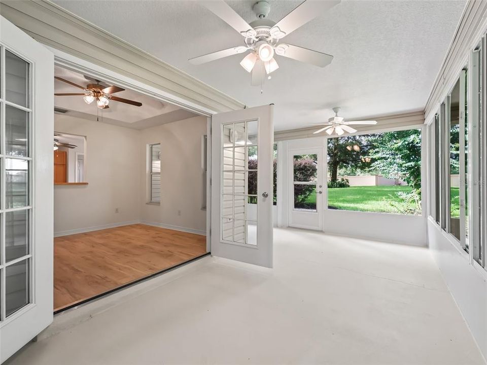 Great Room w/ vaulted ceiling overlooking rear court yard with a newly landscaped colorful garden of bushes, plants.