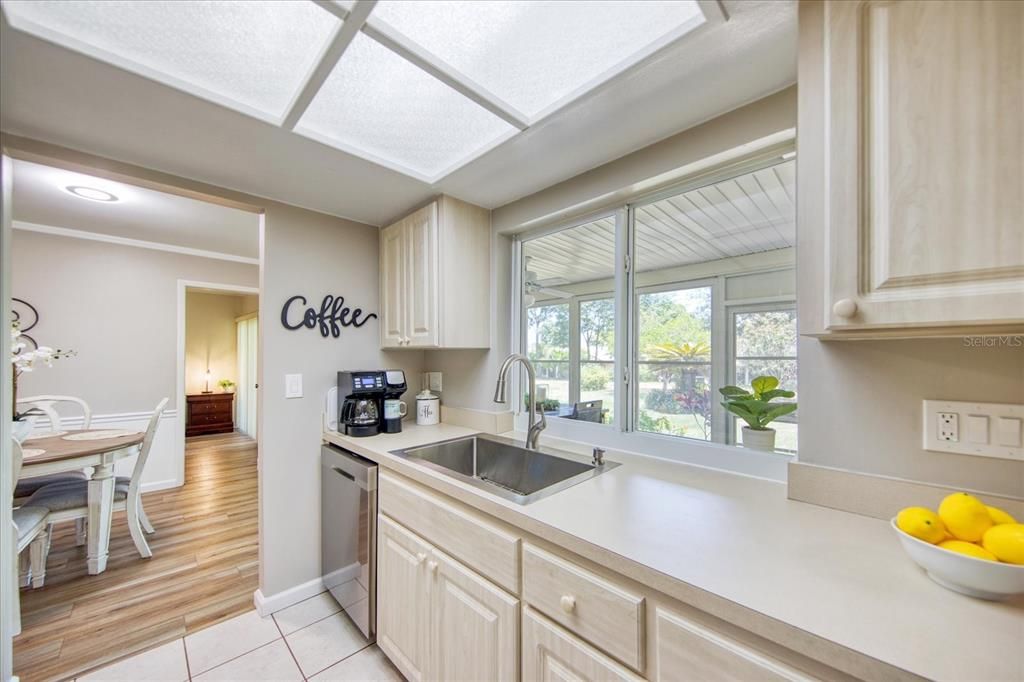 Large window above the newer stainless sink serves as a pass through to the Florida room and allows pretty views of the backyard & lush newer landscaping in 2021~