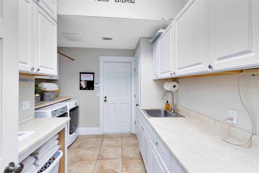 Large oversized laundry room with folding areas and a laundry chute from upstairs.