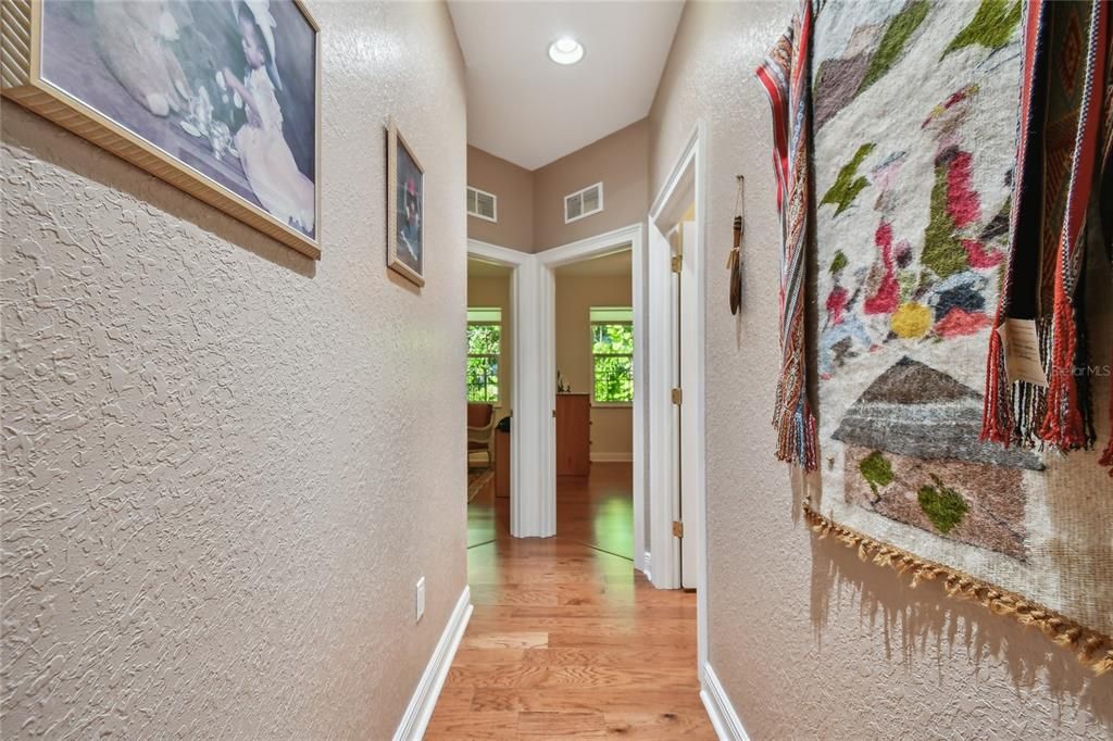 Hallway leading to two bedrooms and one full bathroom